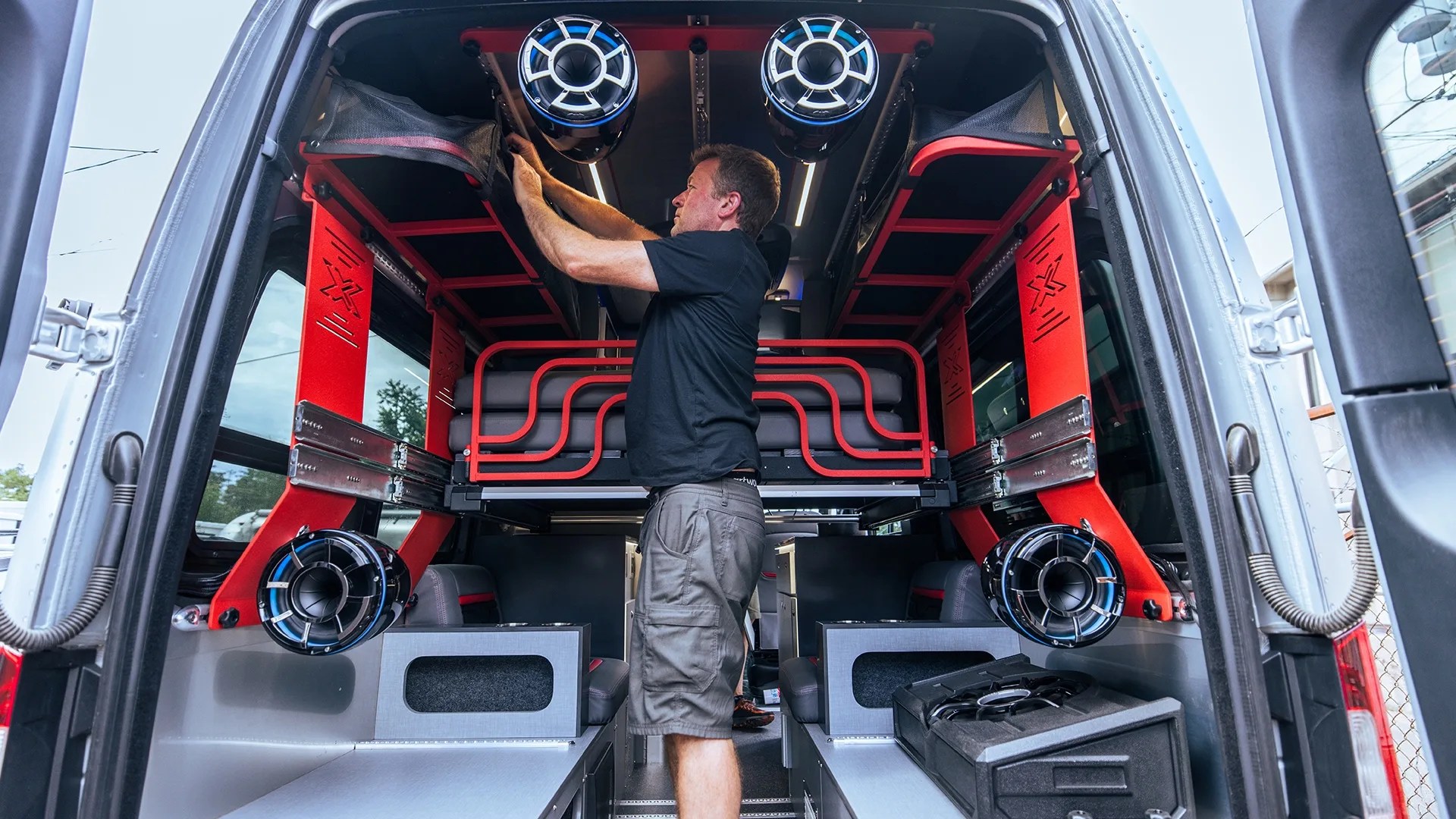 a man stows some gear in an airstream camper van
