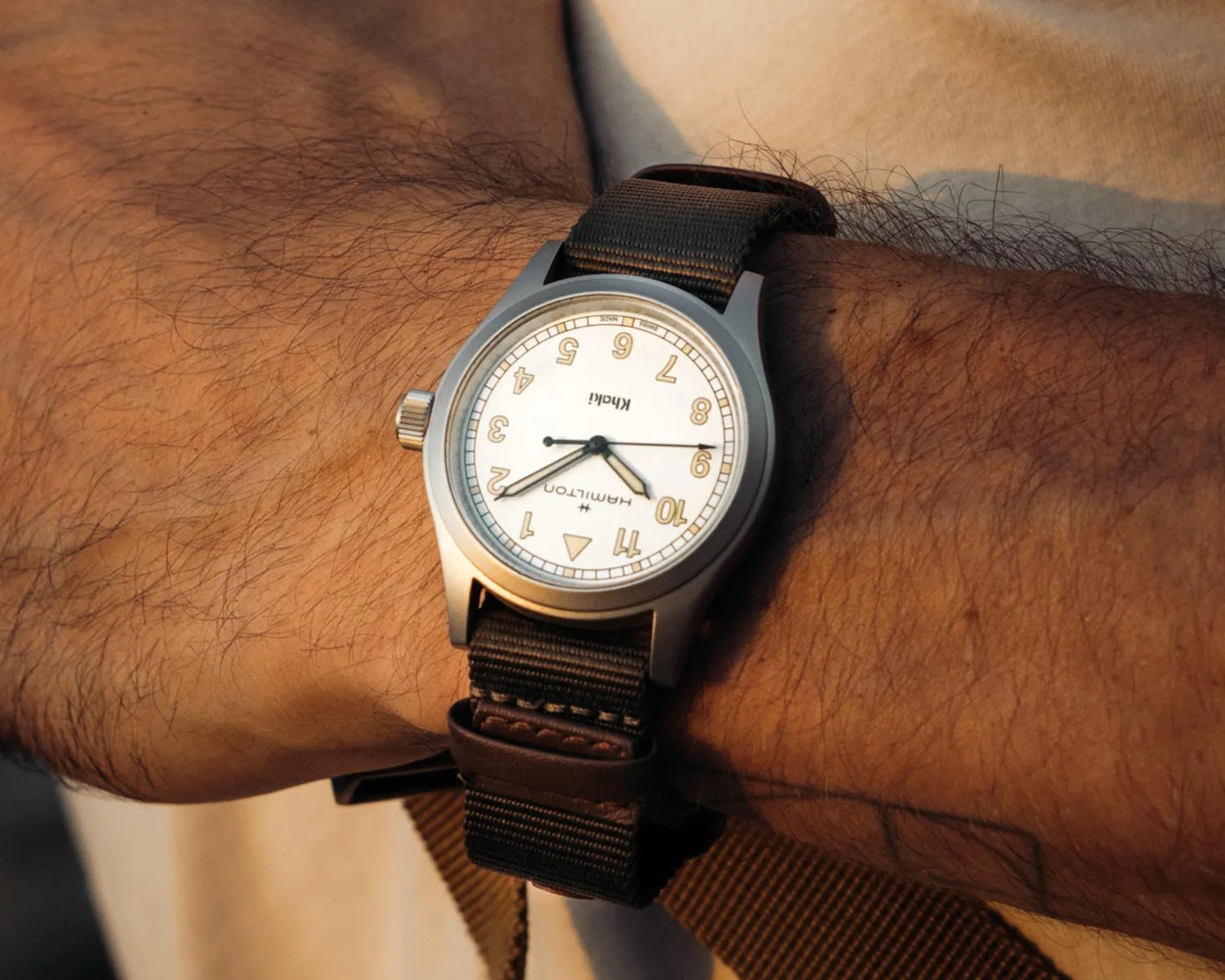 a white hamilton field watch on a mans wrist