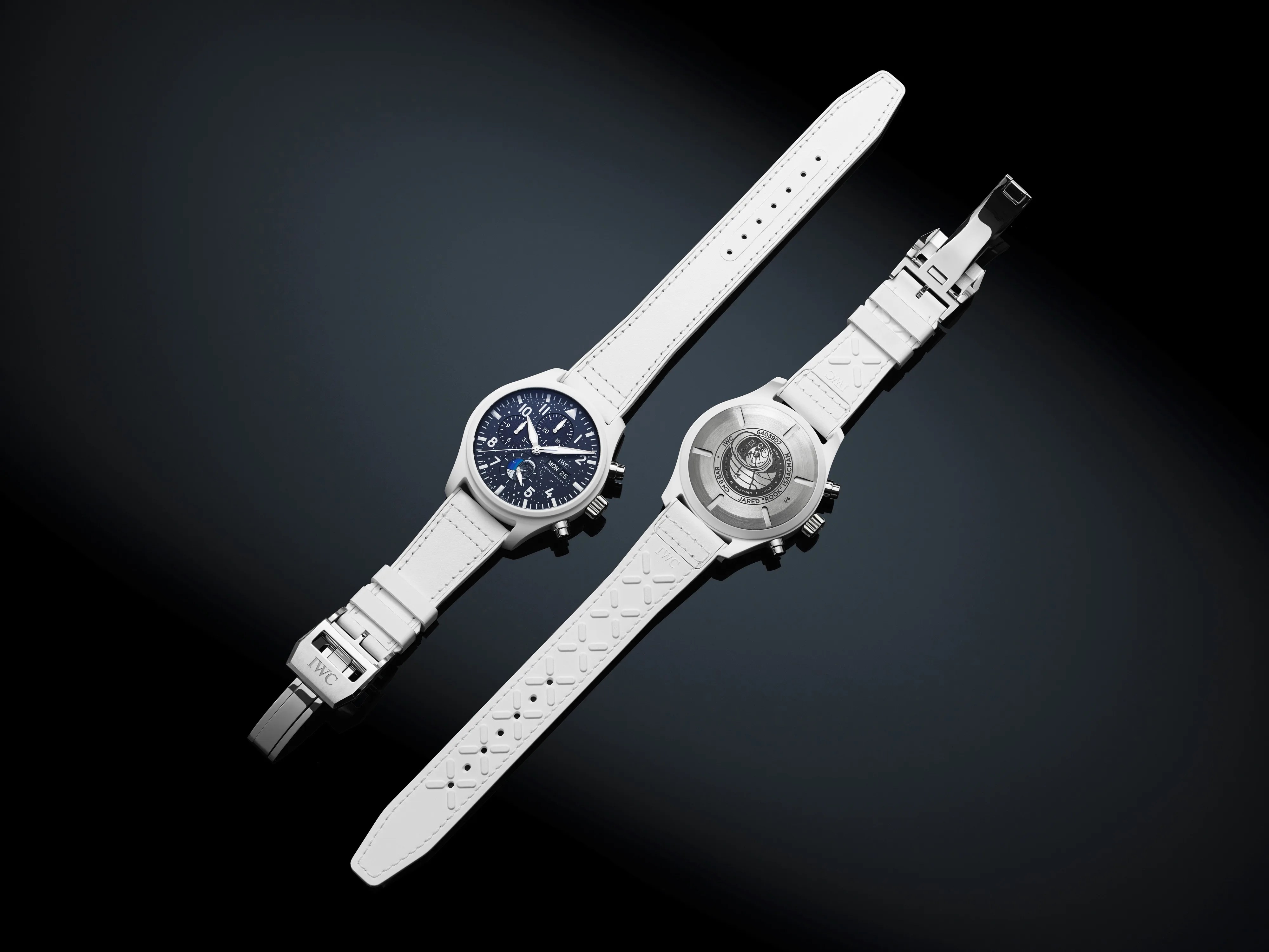 two white iwc watches with one face up and one face down