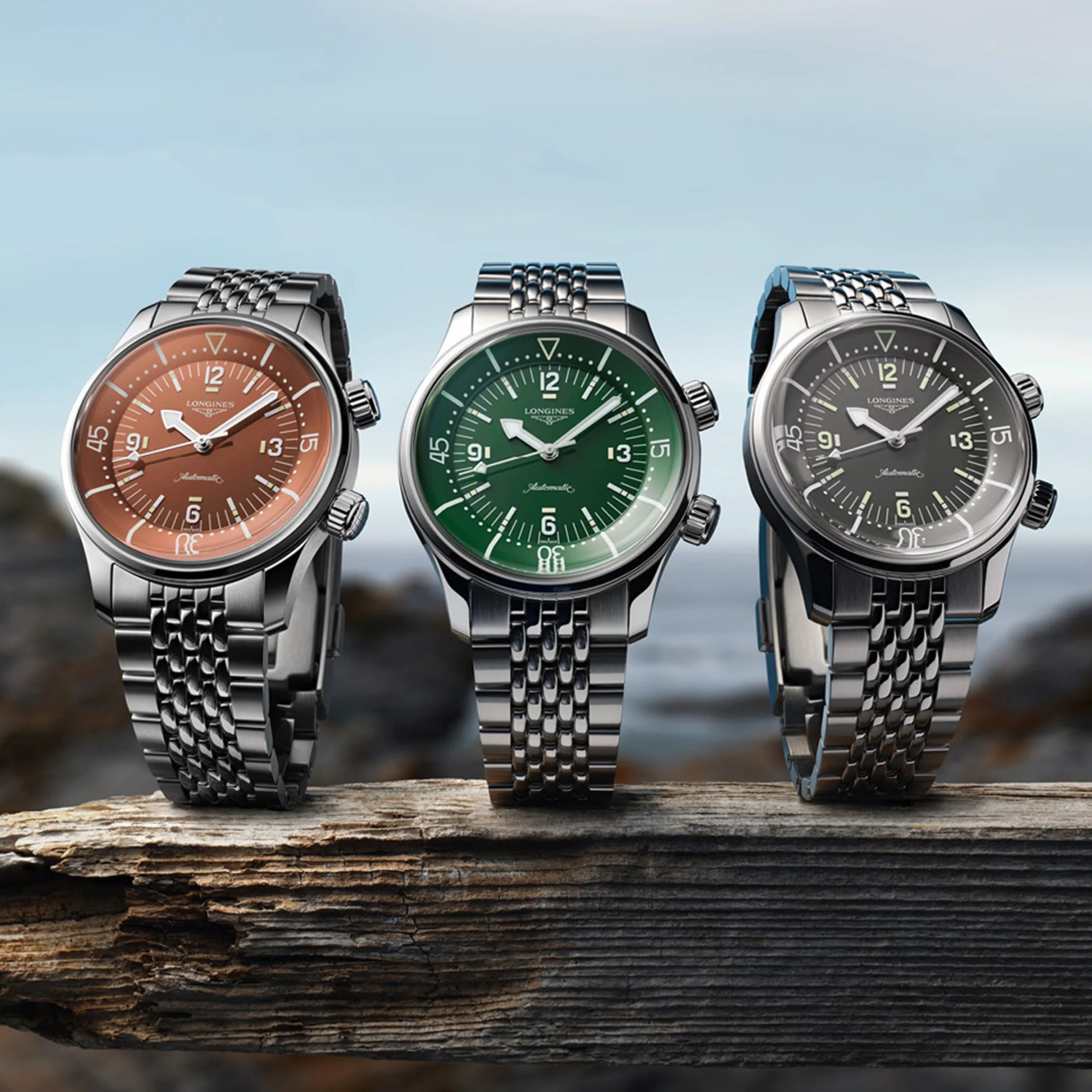 three longines dive watches on a beach