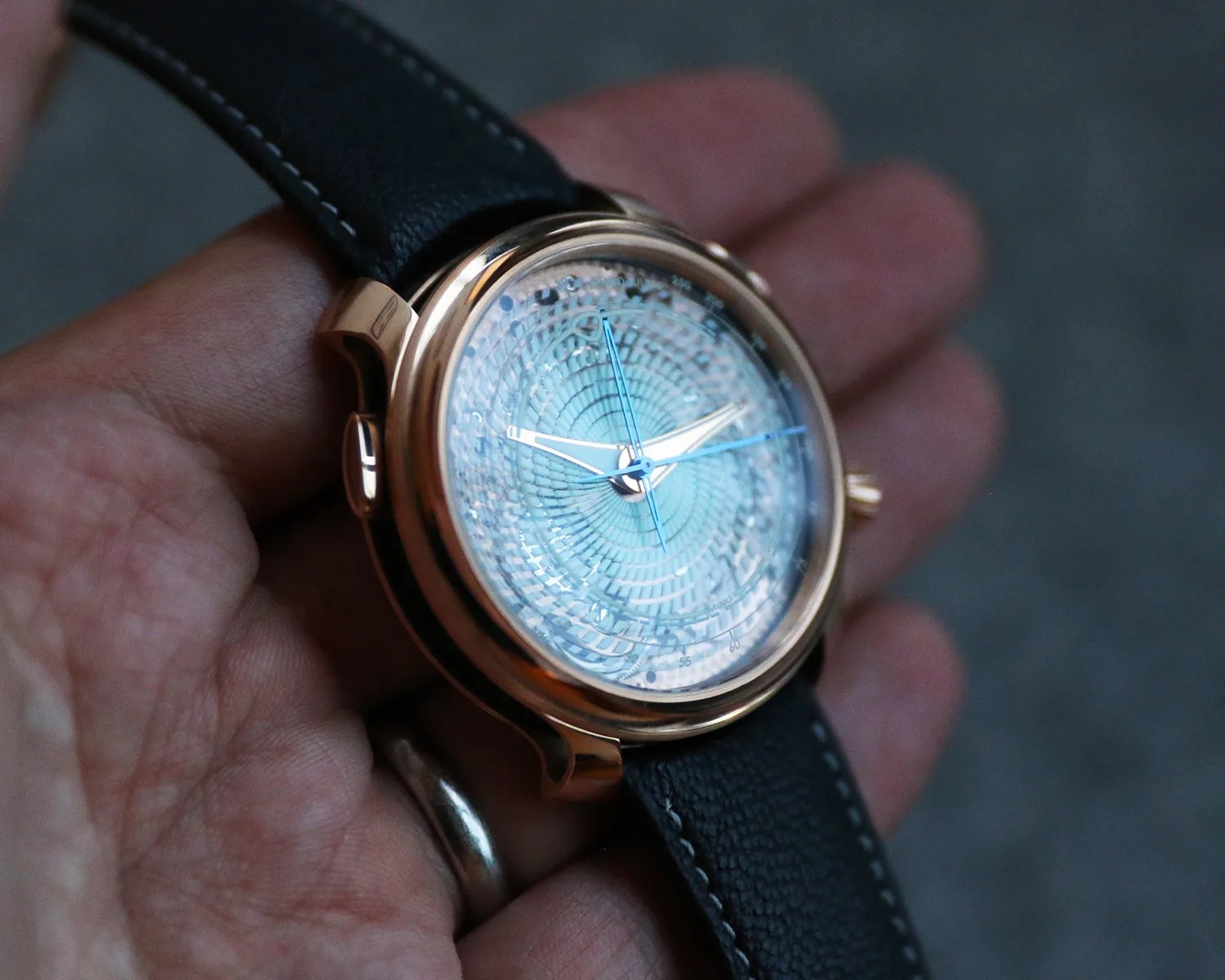 a ming watch held in a mans hand