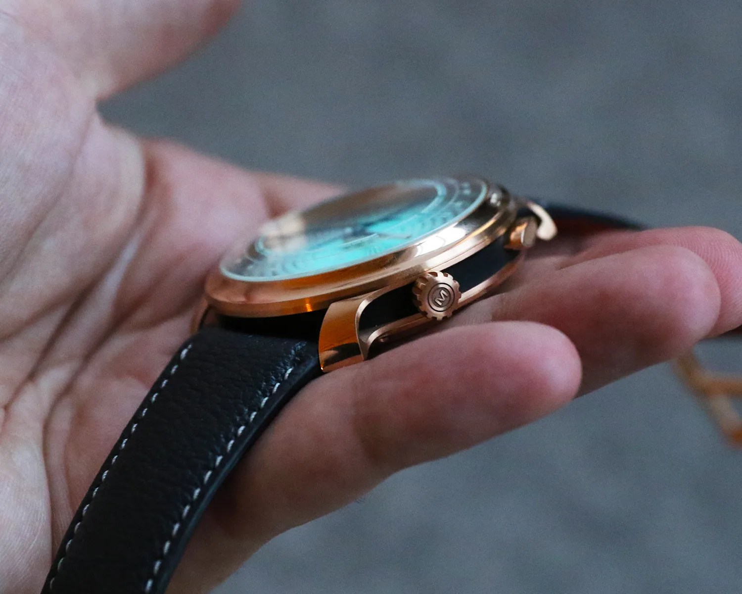 ming watch held in a mans hand