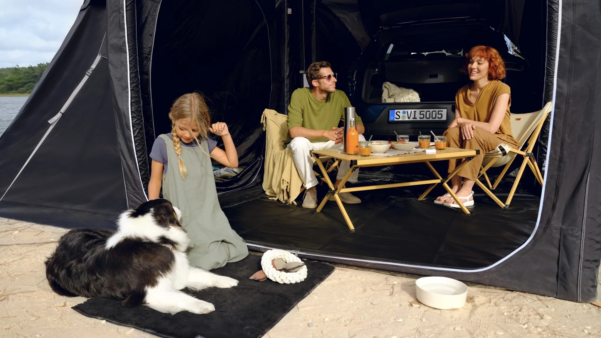 a family sits at a table inside a large porsche tent
