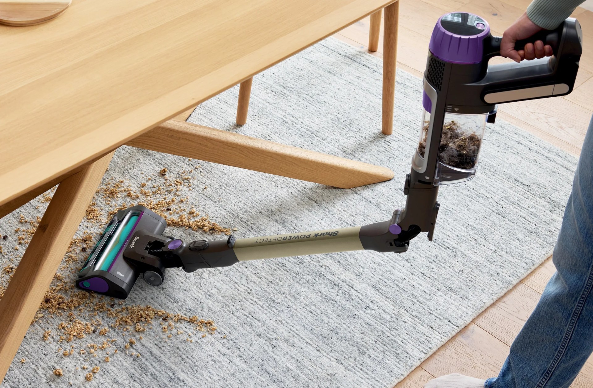 A vacuum cleans up spilled debris beneath a kitchen table
