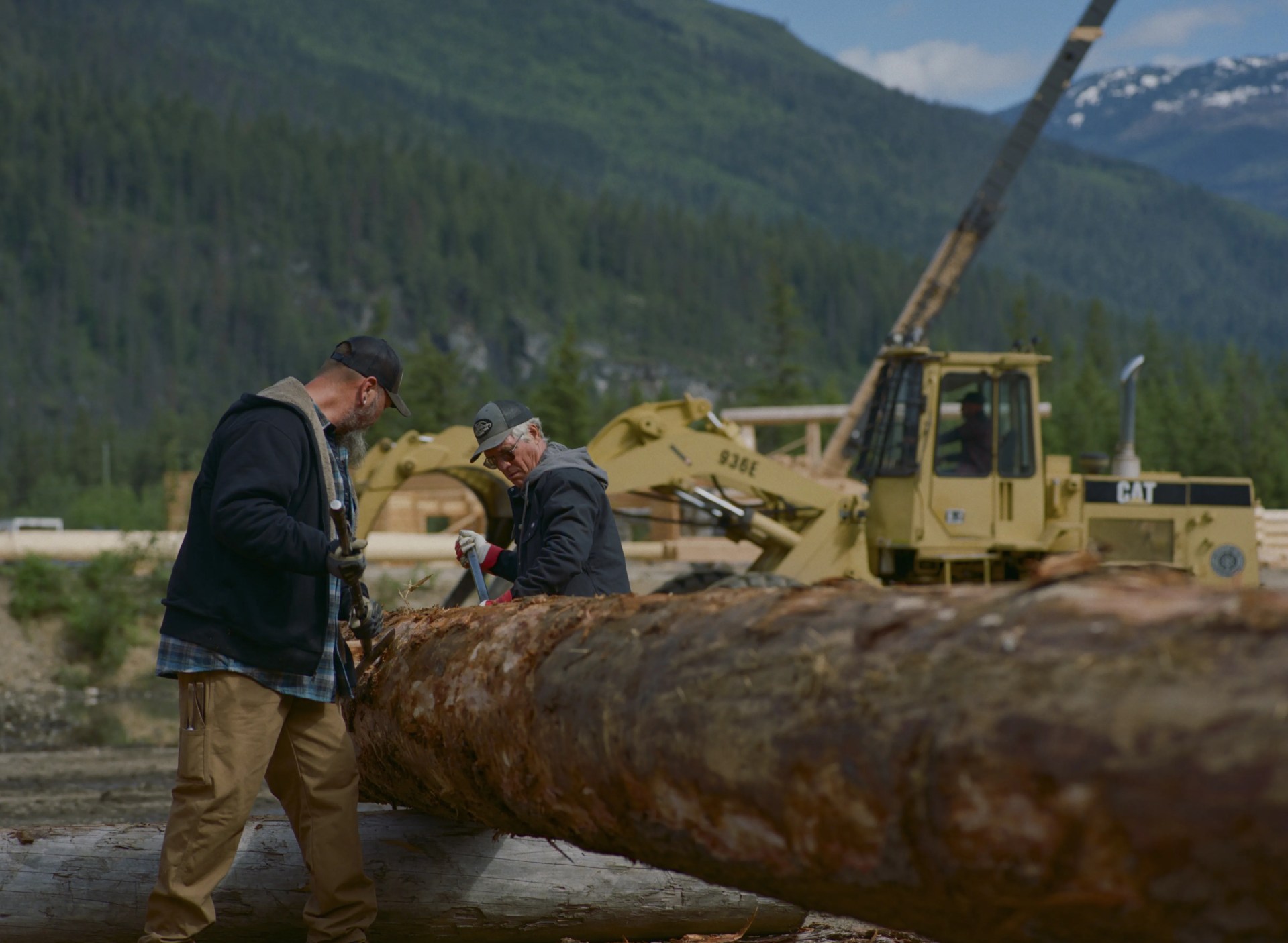 Two workers handle a large log