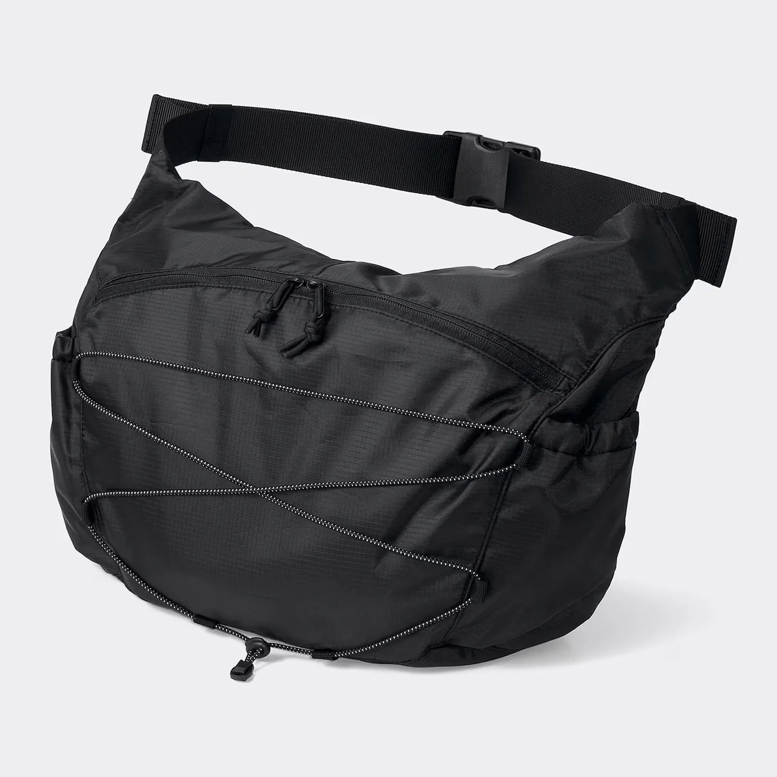 GU Ripstop messenger bag in black sitting upright and filled on a grey background.