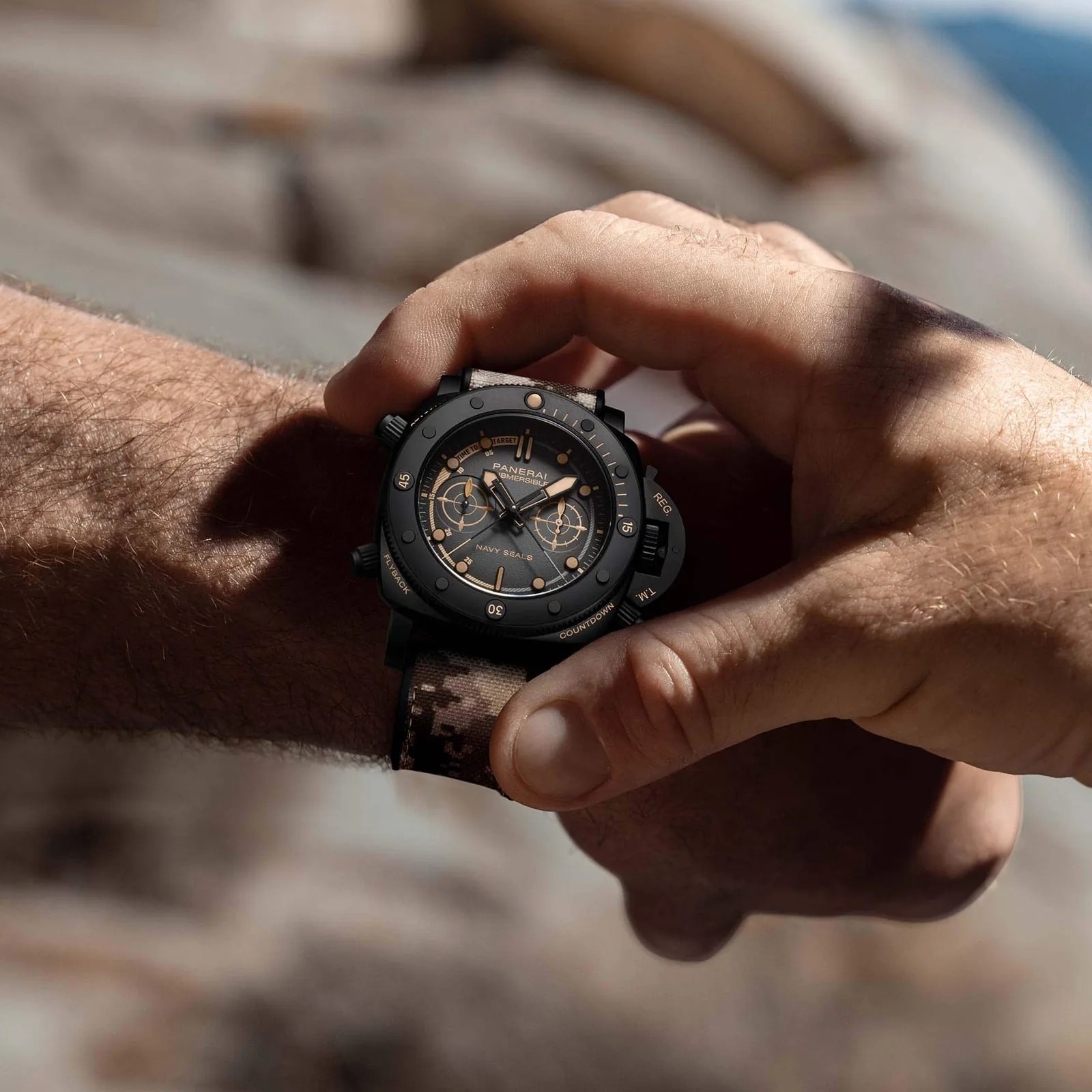Panerai Submersible Chrono Navy SEALs Titanio worn on male wrist while opposite hand triggers the chronograph function.