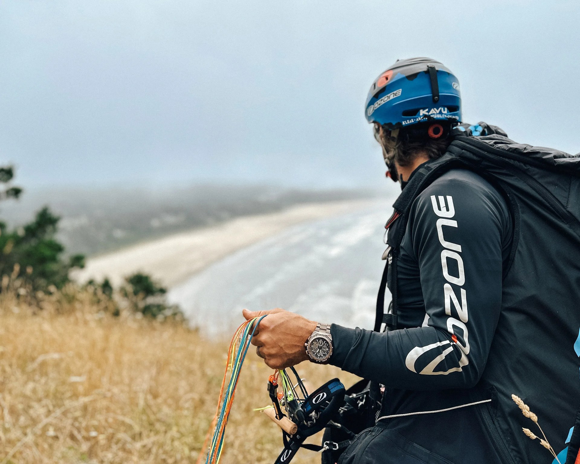 watch on wrist of paraglider looking at ocean