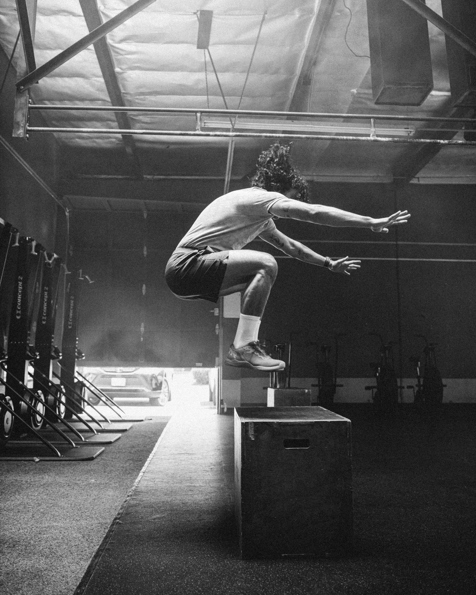 black and white photo of man in a gym