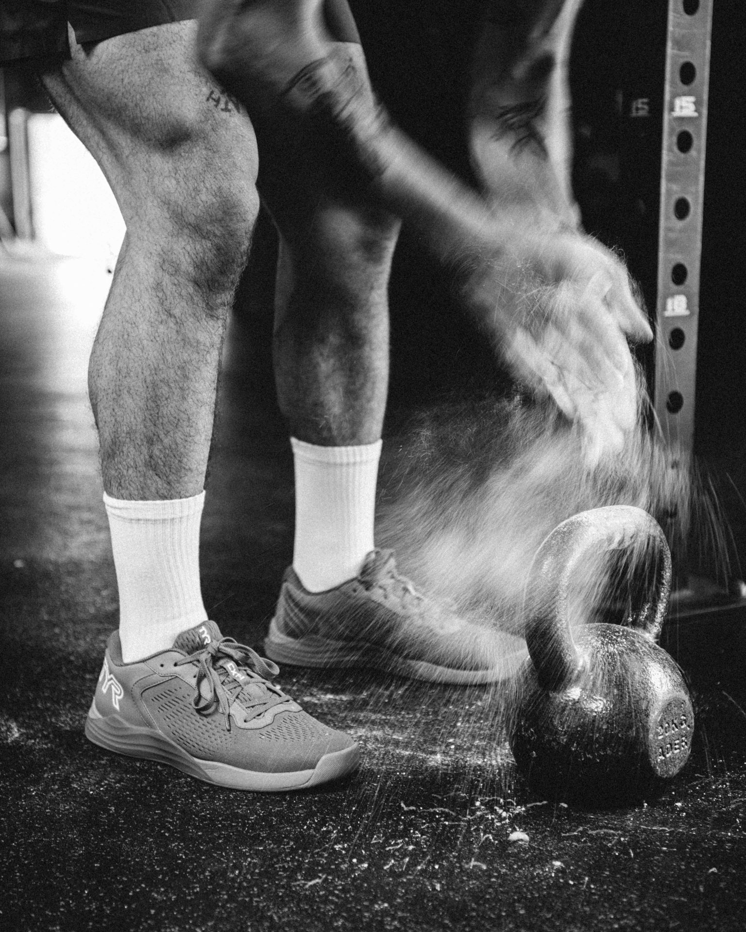 black and white photo of man in a gym
