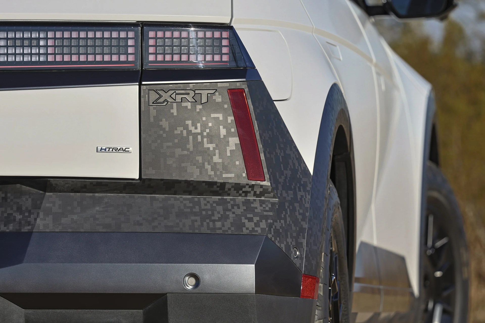 A detailed shot of the rear back corner of a white 2025 Hyundai Ioniq 5 XRT showing the trim’s special digital camo trim. 