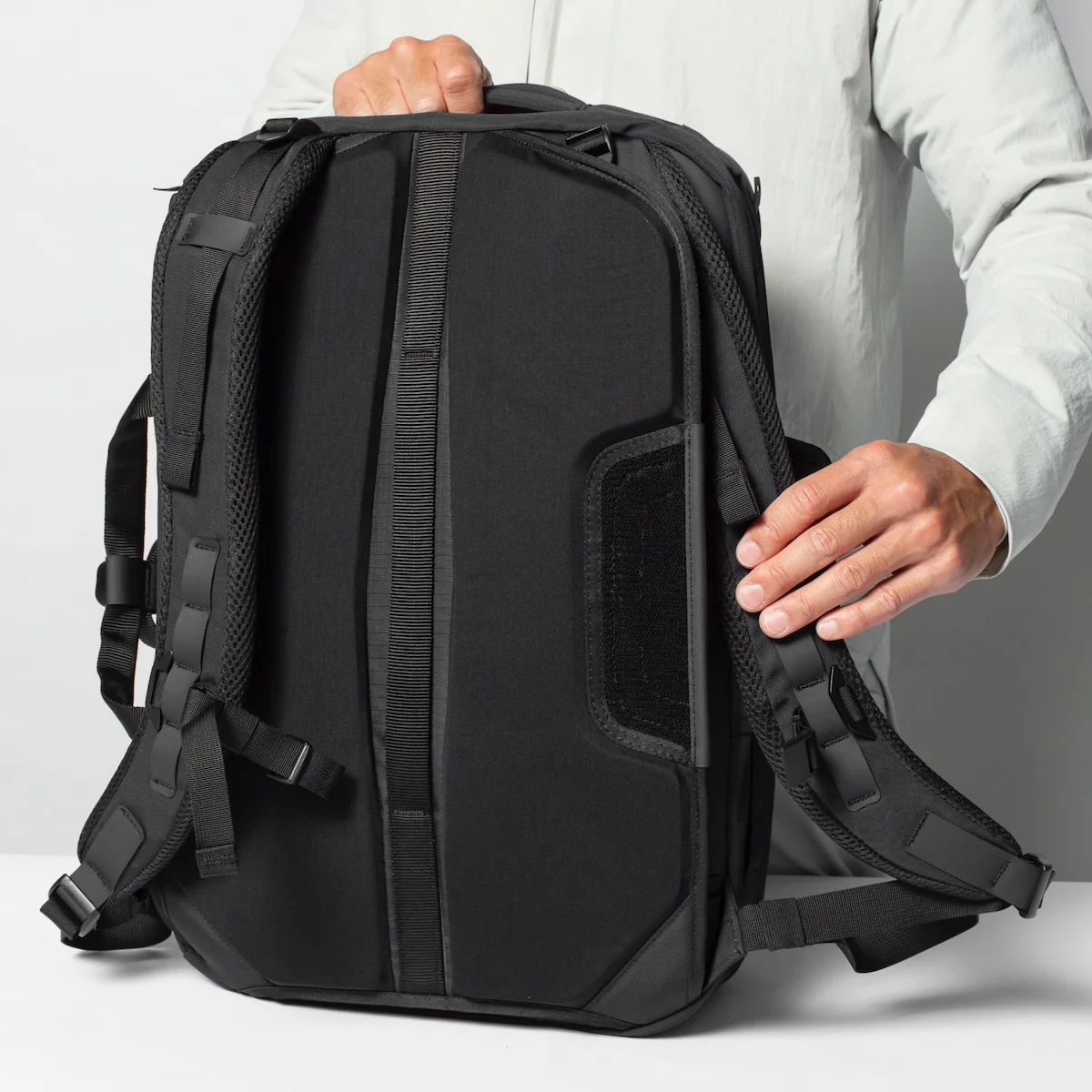 The back of the Black Ember Forge 40 travel backpack showing the bags butterfly back-panel which can hide the backpack straps out of the way. 