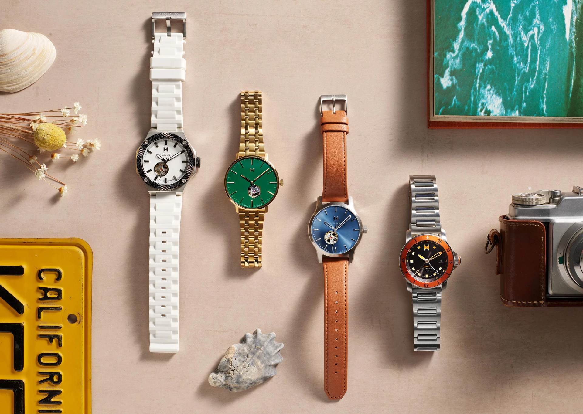 four watches on table with props