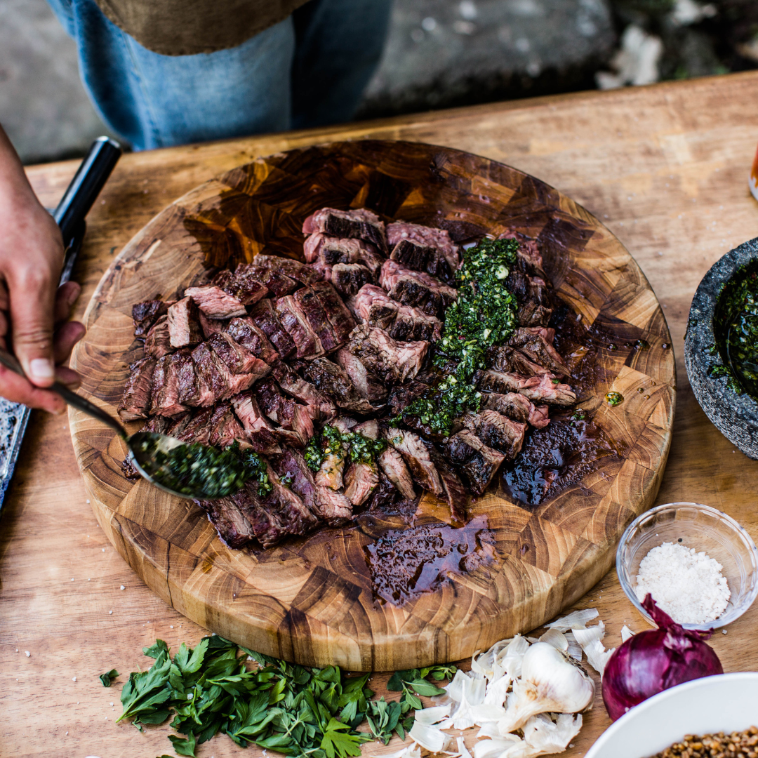 sliced grilled steak on a wooden cutting board