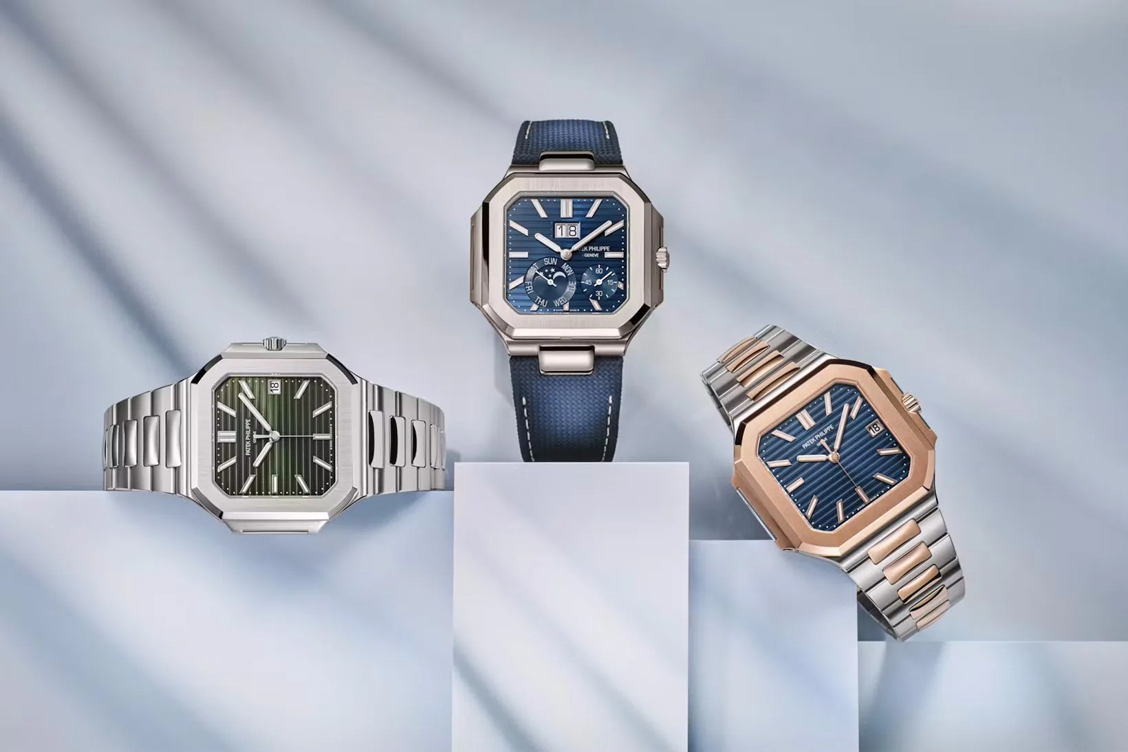 The three watches included in the Patek Philippe Cubitus collection displayed leaning against white and grey blocks on a white and gray background.