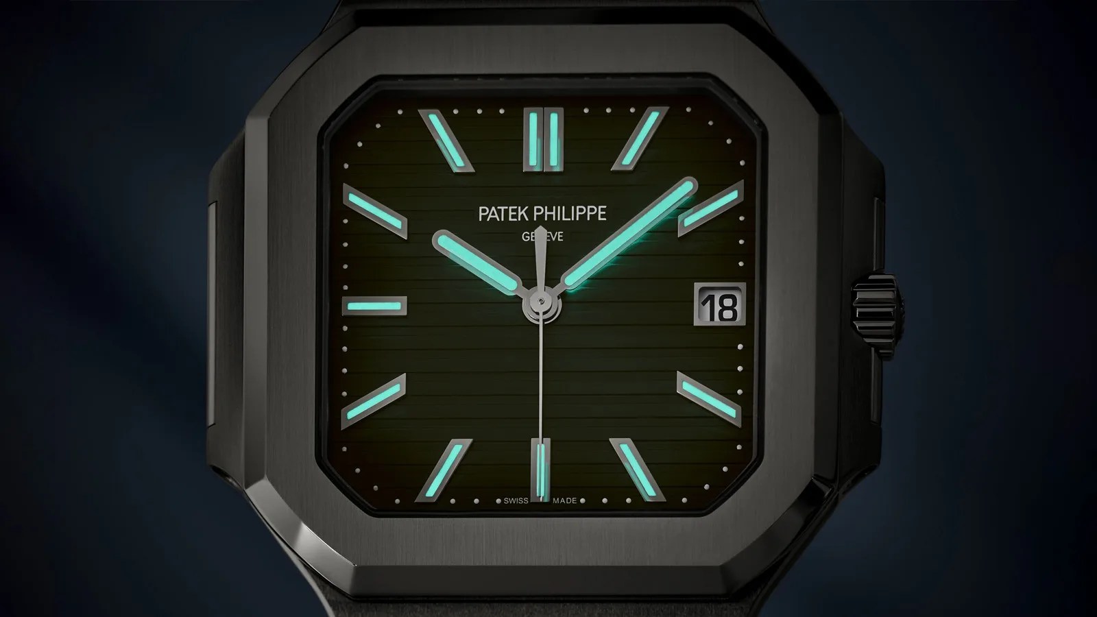 A close up of the face of the Patek Philippe Cubitus 5821/1A shown darkened to highlight the lume on the numbers and watch hands.