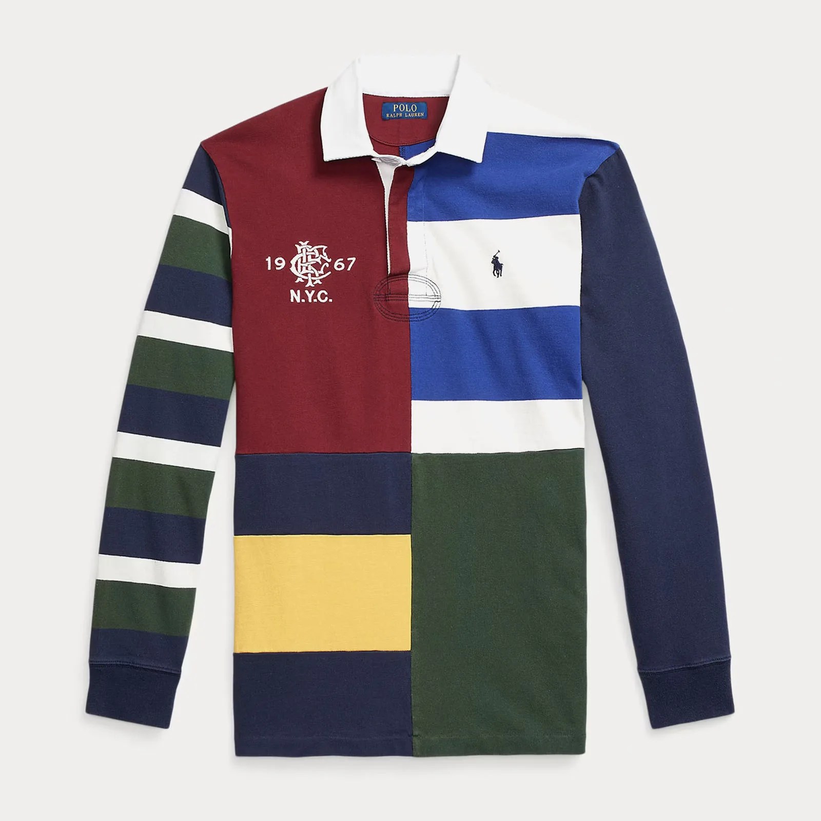 A patch work rugby shirt laid flat against a light grey background. This shirt is made by Ralph Lauren and features bold stripes in various colors in a patch work fashion. 