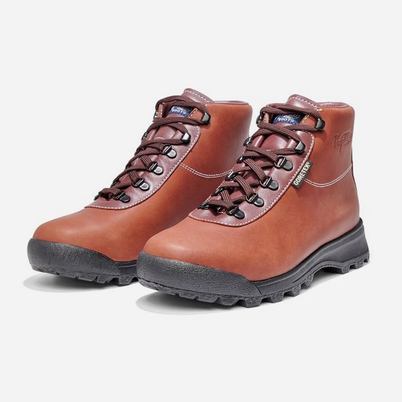 A pair of Vasque Sundowner boots in brown shown at a angle shot against a light grey background.