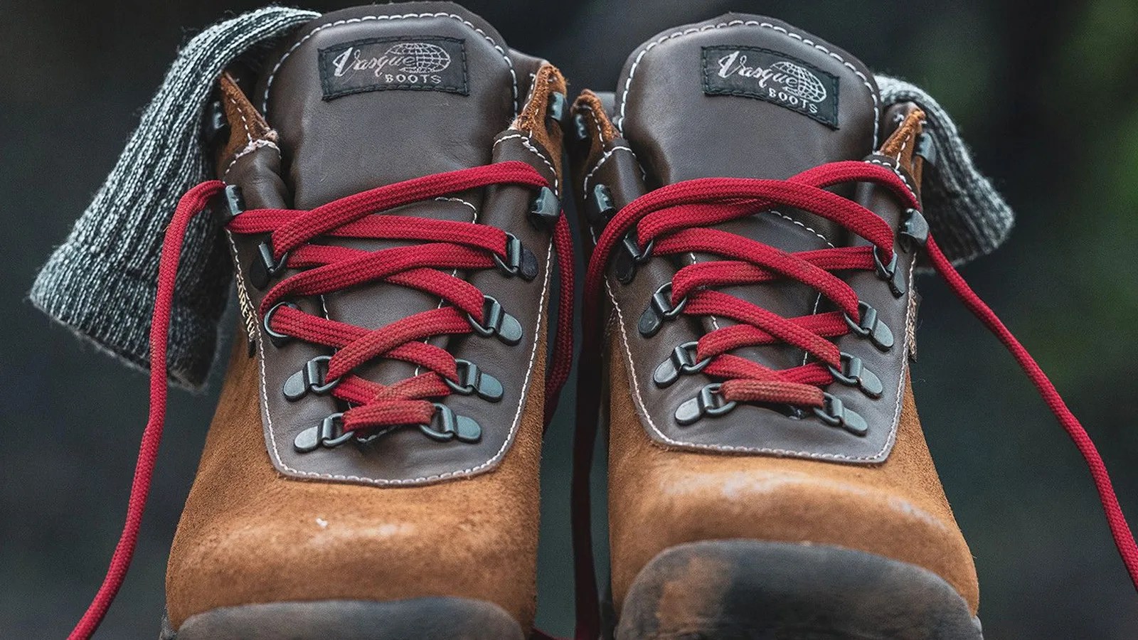 A straight ahead look at pair of Vasque Sundowner boots showing the boots red laces contrasting with the boots grey colored upper and light tan leather base.
