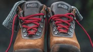 A straight ahead look at pair of Vasque Sundowner boots showing the boots red laces contrasting with the boots grey colored upper and light tan leather base.