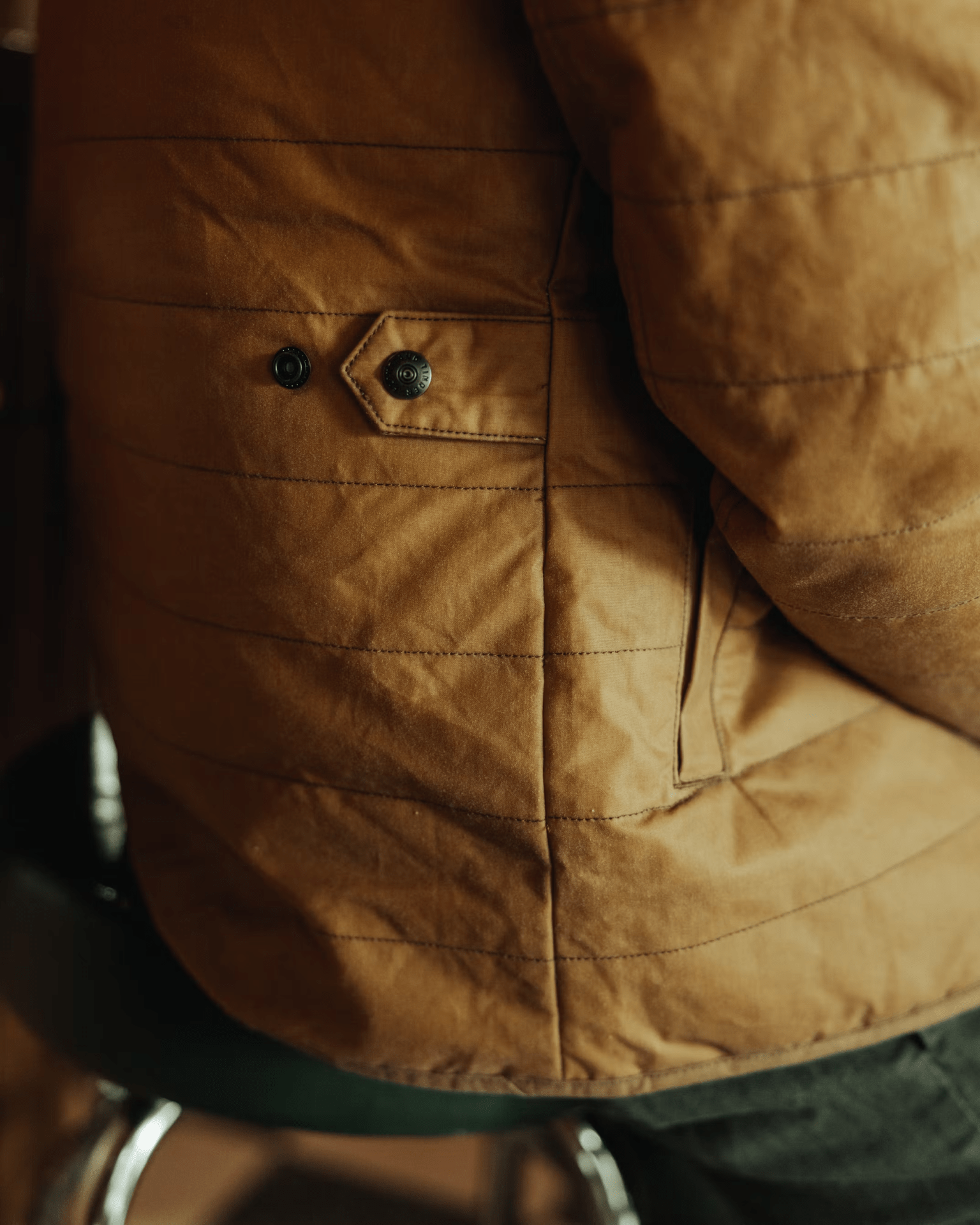 A close up of the back edge of Flint and Tinder's York Quilted Waxed Jacket  