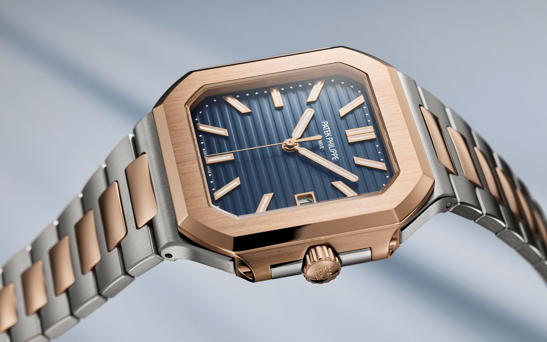 The Patek Philippe 5821/1AR Cubitus shown suspended flat at an angle to highlight the face and drape of the watch bracelet