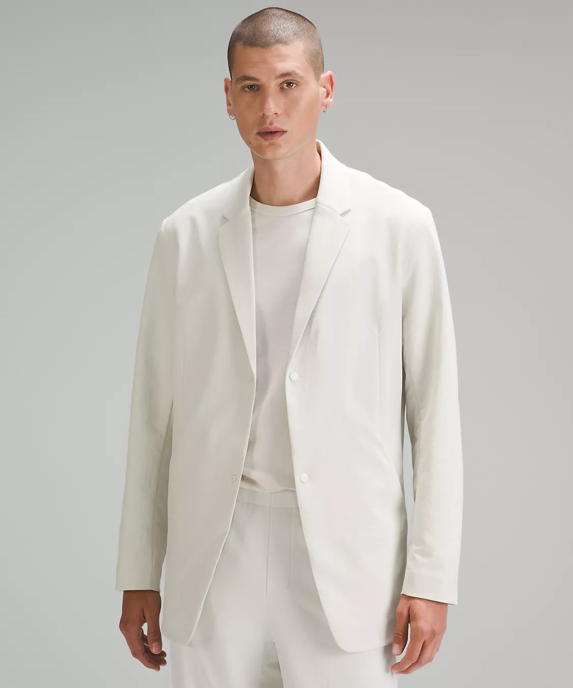 Lululemon New Venture Blazer in white being worn by a male model with a shave head wearing matching white pants and a t-shirt