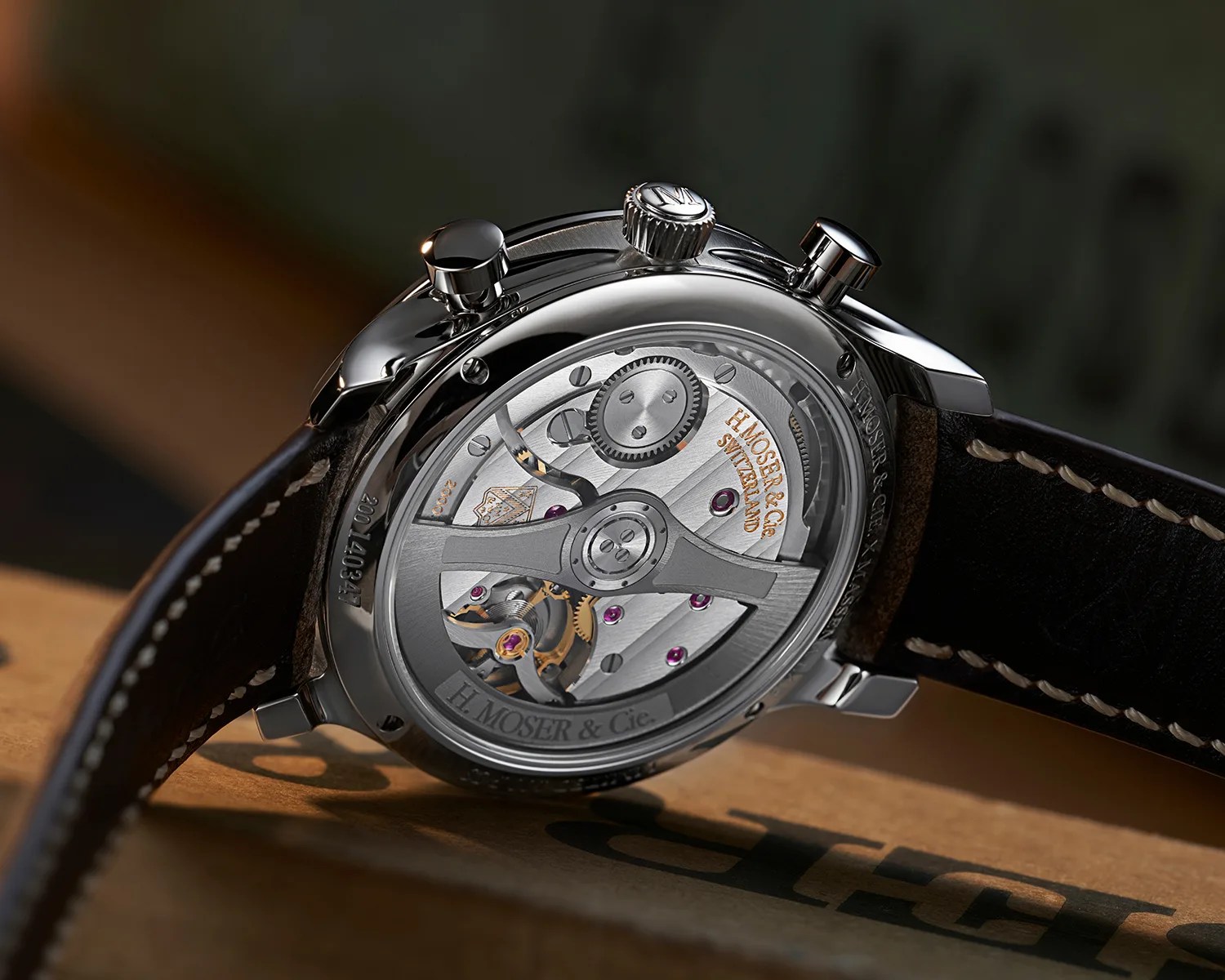 the mechanical movement of a moser x massena lab watch seen through a sapphire caseback