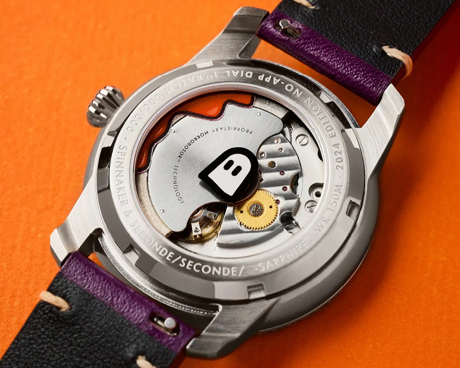 Spinnaker watch display caseback showing mechanical movement and a cartoon ghost
