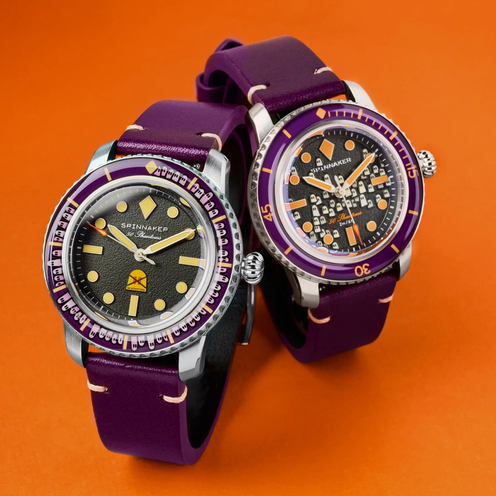 two spinnaker watches on an orange surface