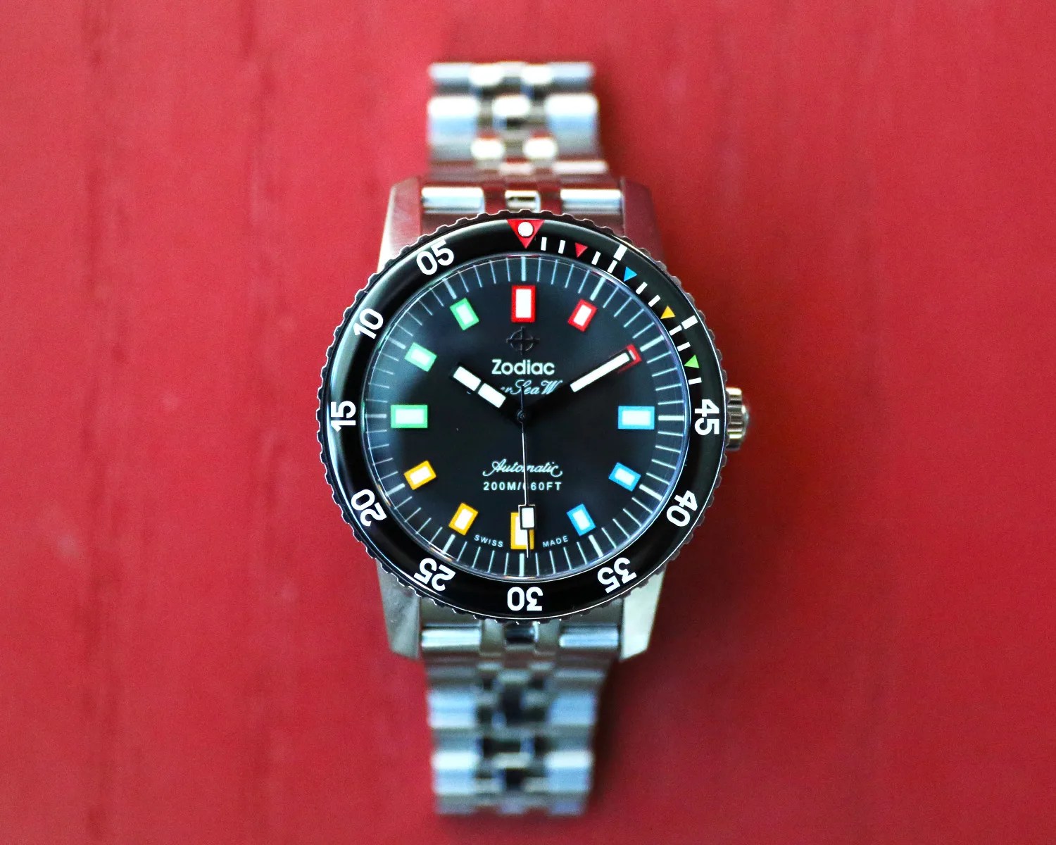 zodiac dive watch on a red wooden surface