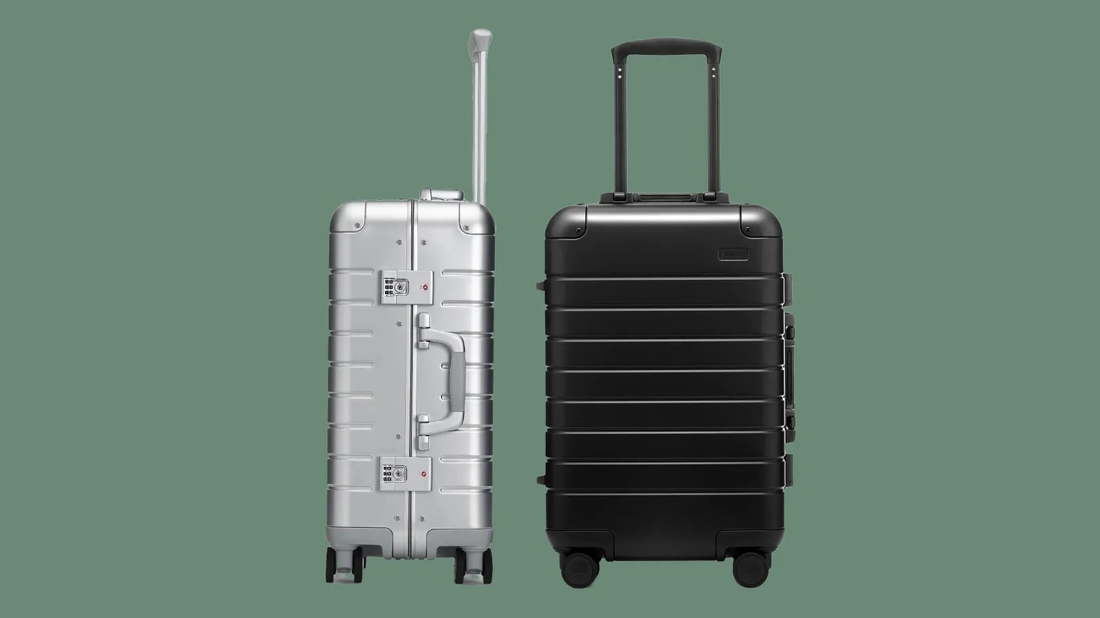 Two away aluminum suitcases sitting next to each other against a dark green background. The left bag is silver and shown in profile. The right black is metallic black and shown head on.