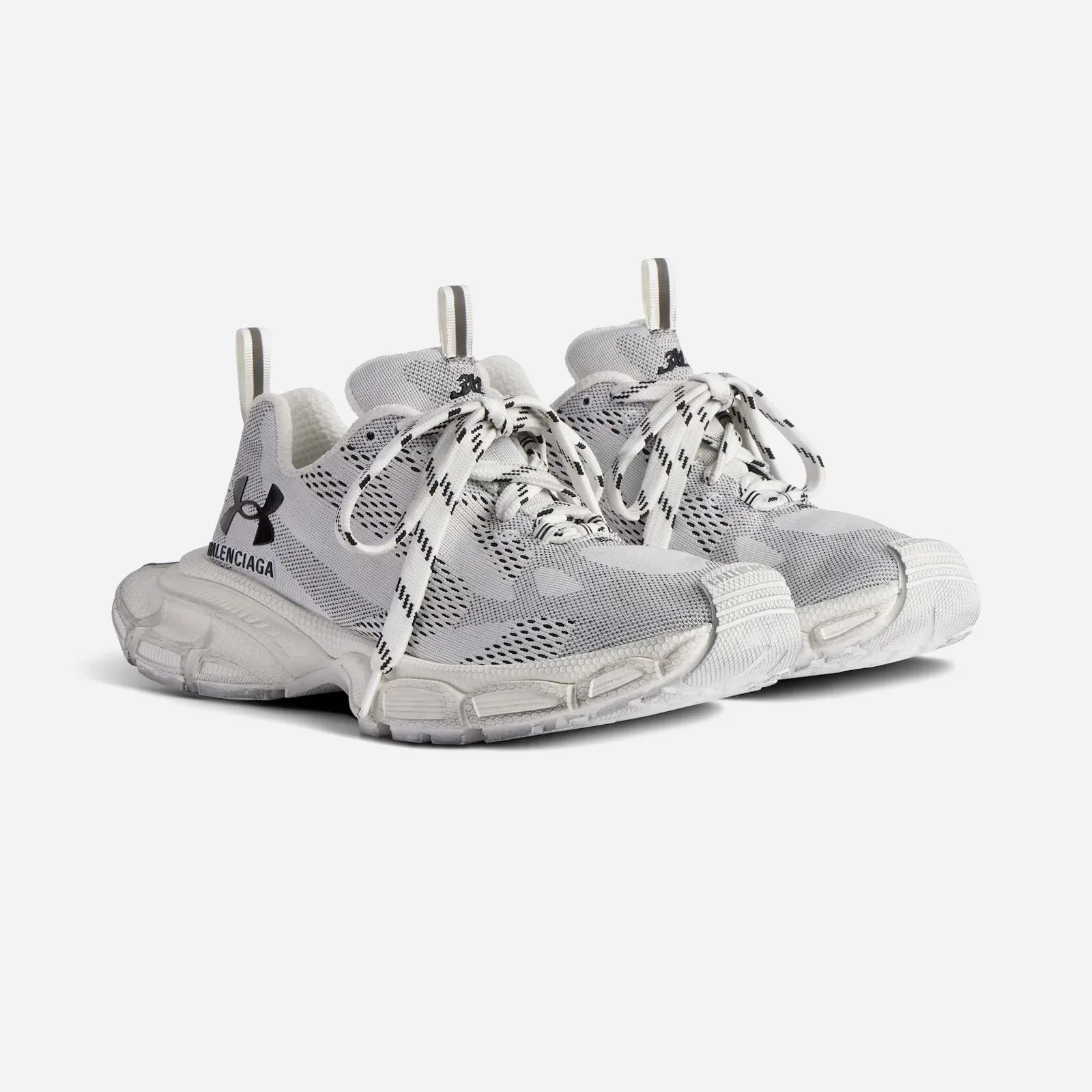 A pair of Balenciaga x Under Armour 3XL sneakers in white shown facing diagonally against a light grey background. 