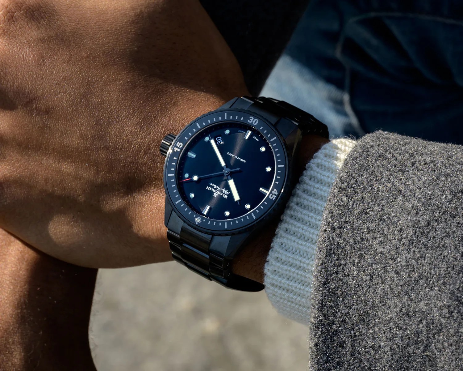 a blancpain fifty fathoms ceramic dive watch on a mans wrist