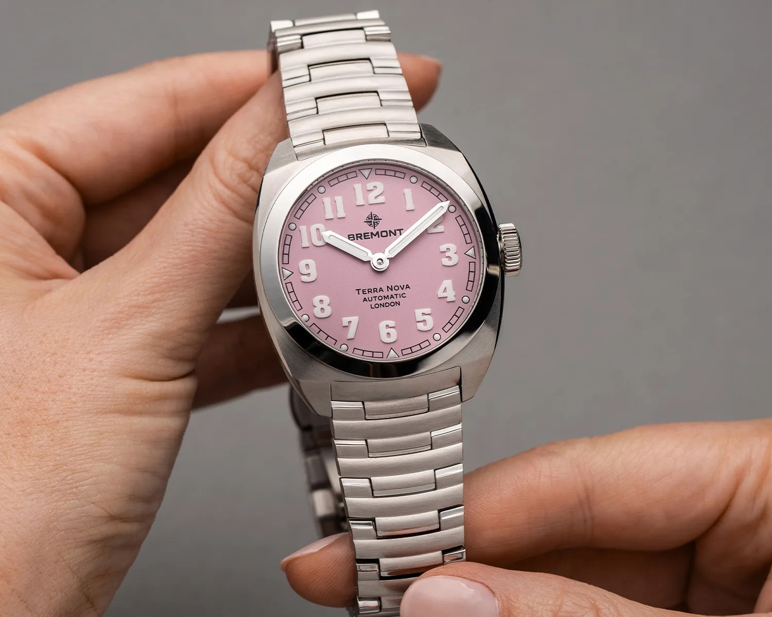 a person holds a pink bremont field watch