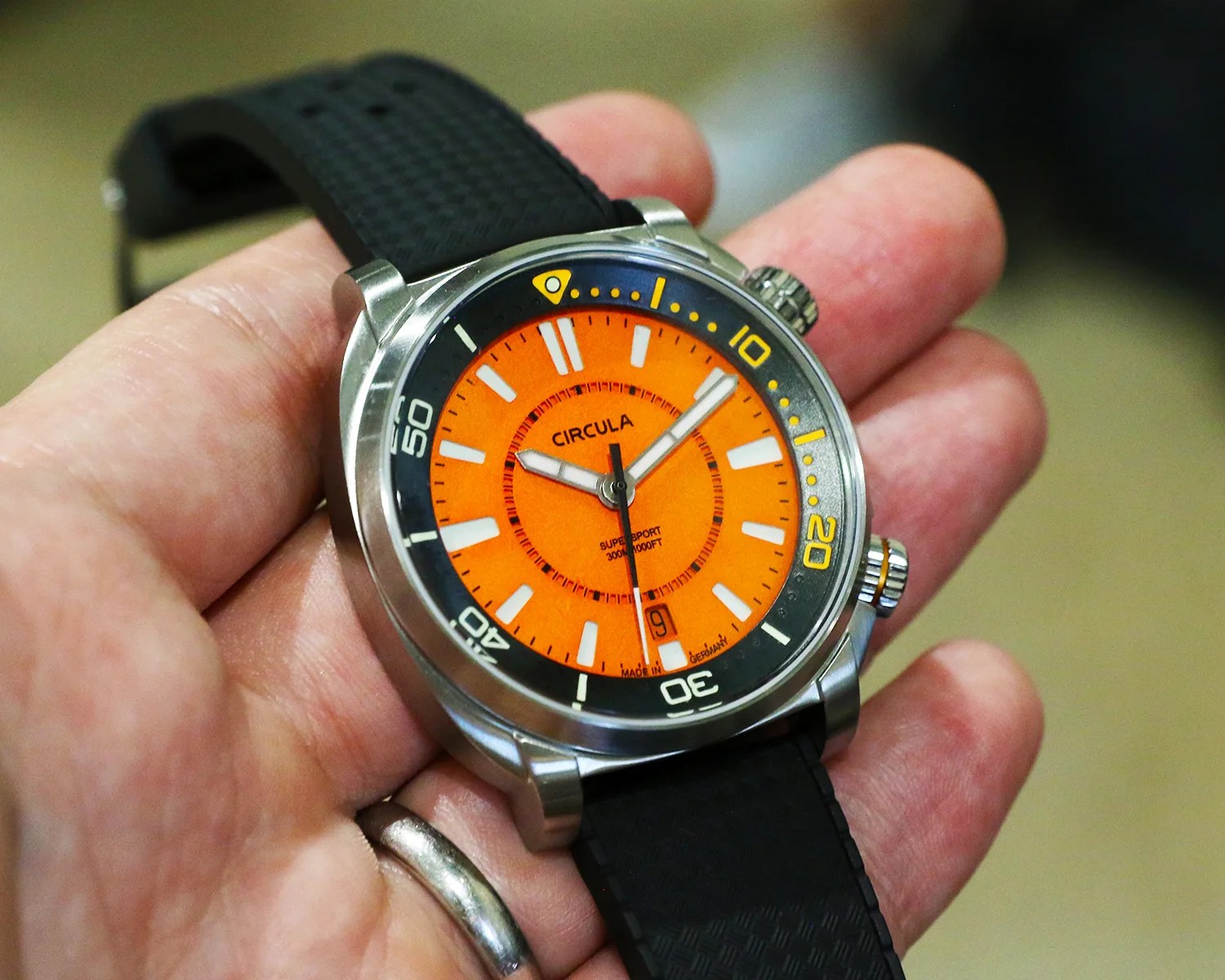 a circula dive watch held in a persons hand