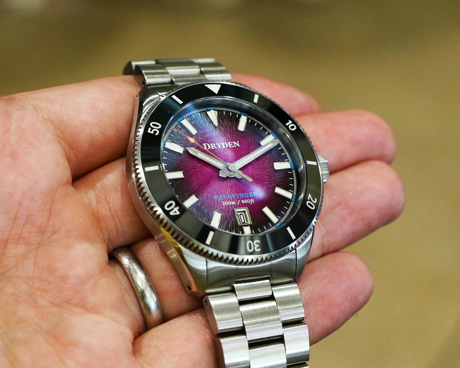 a dryden dive watch held in a persons hand