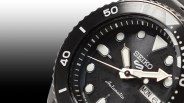 a closeup of a seiko x beams watch dial against a black gradient background