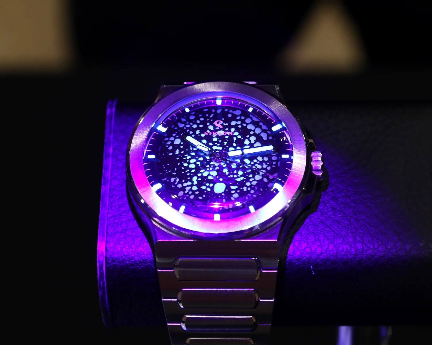 a straum watch glows under a blacklight