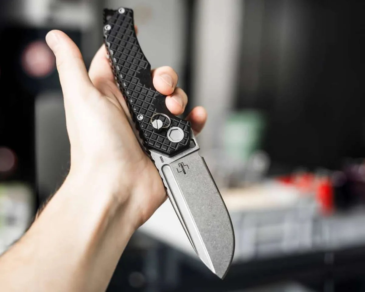 Böker Plus Hermod Folder in someone's hand in front of blurry background