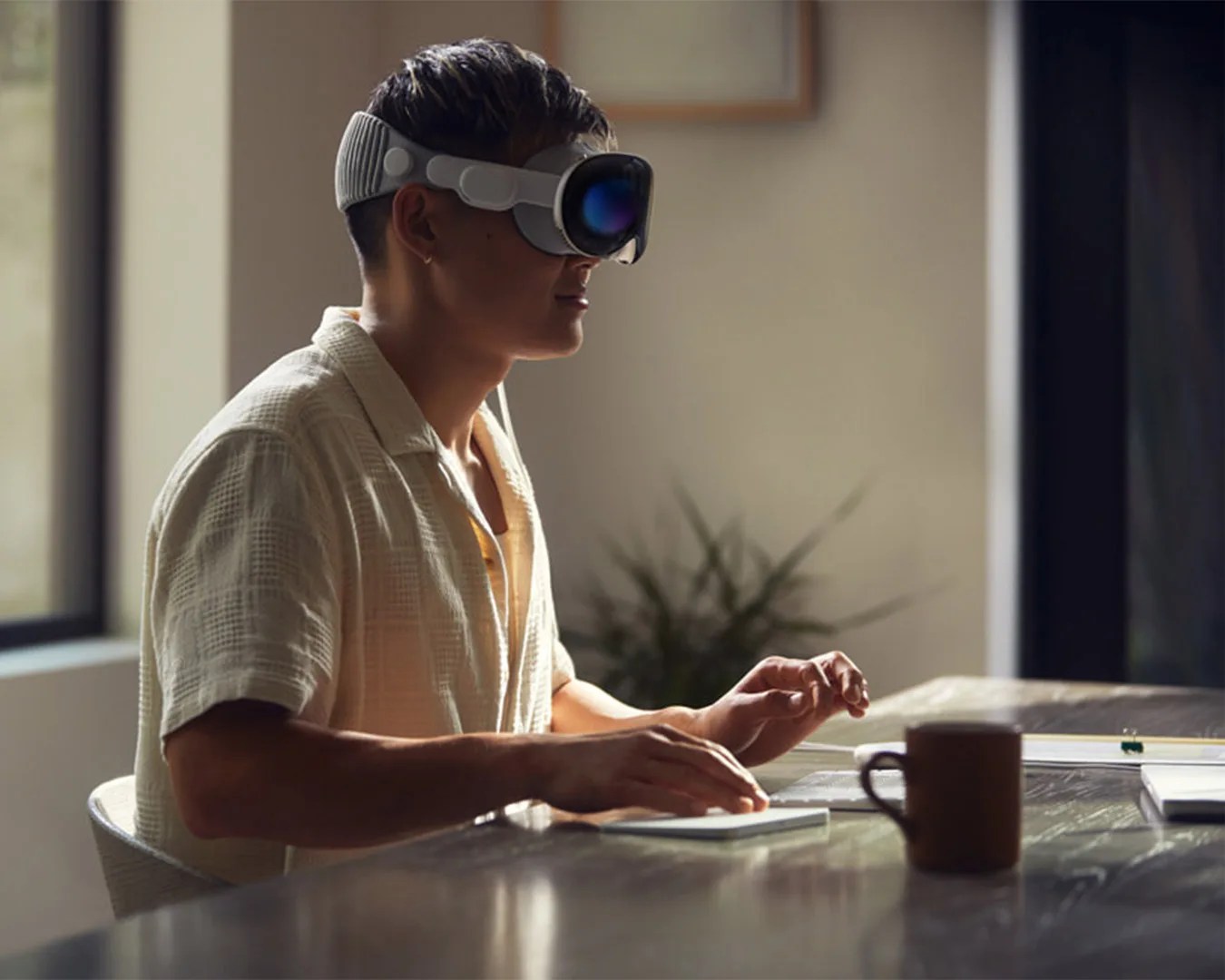man sitting at desk using Apple Vision Pro