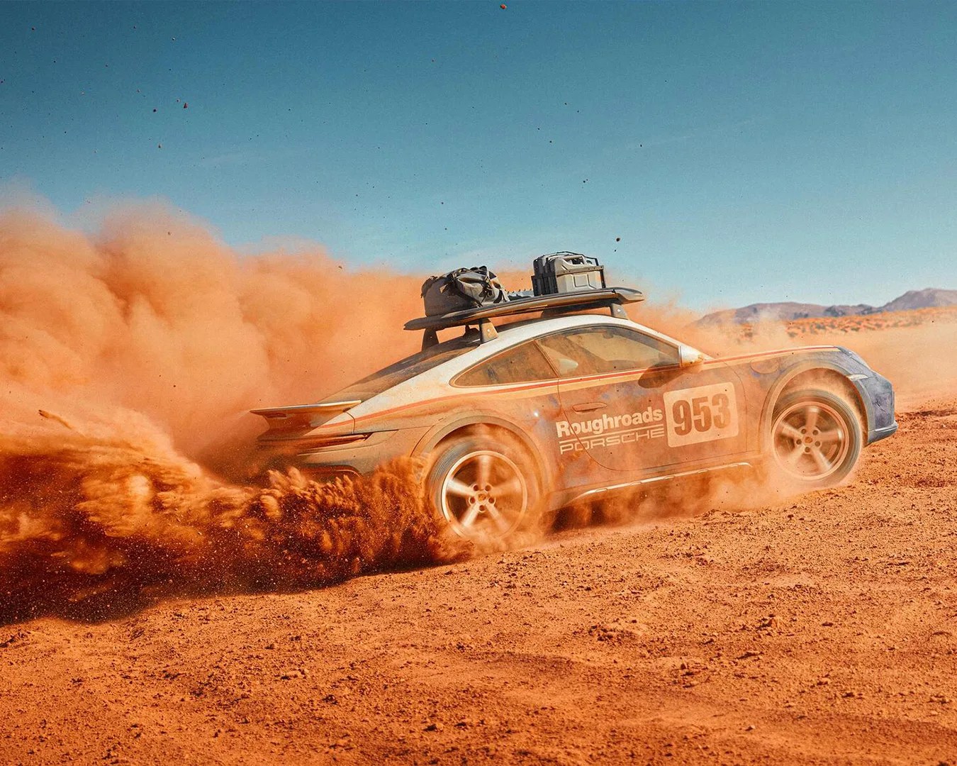 Porsche 911 Dakar car speeding through dirt path and blowing dust back