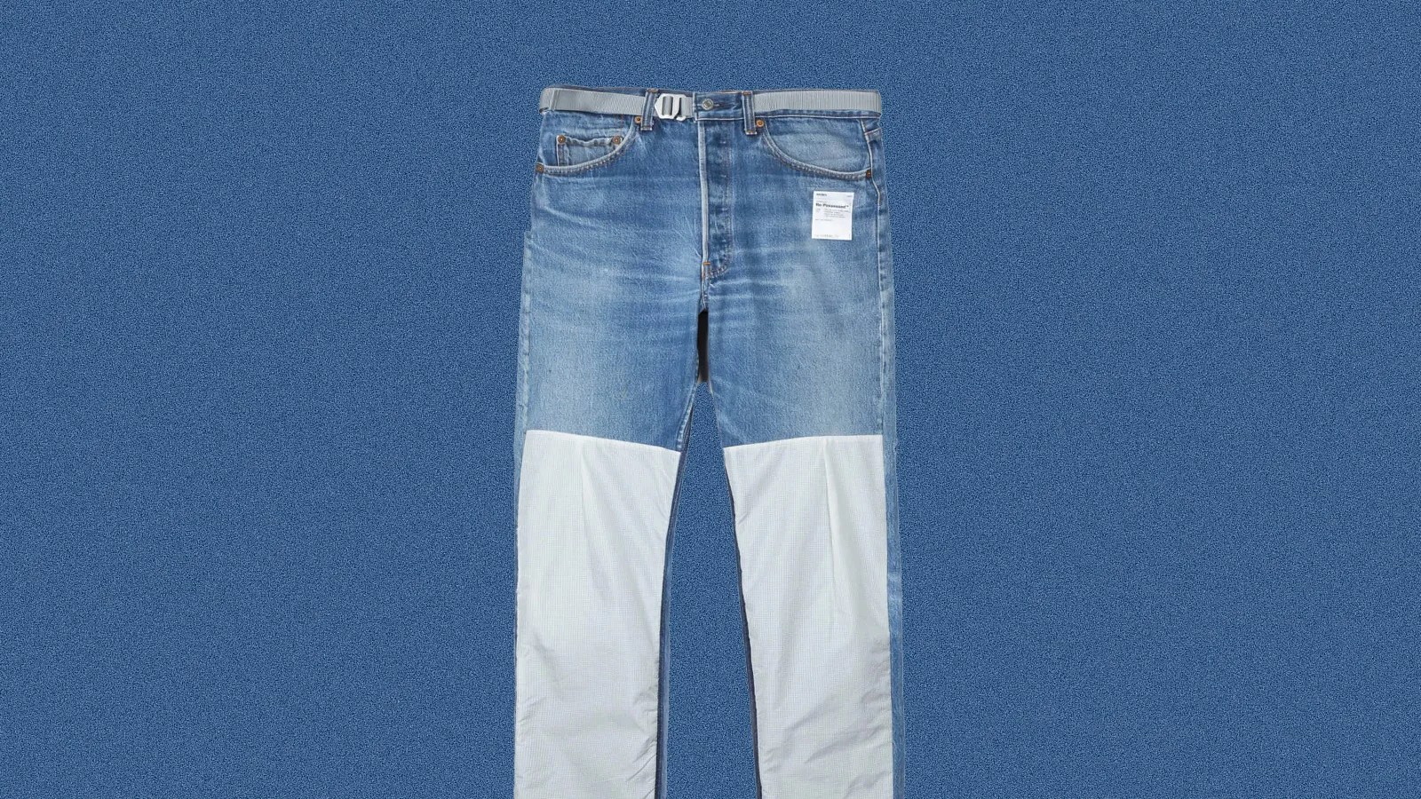 A pair of Levi's 501 re-possessed climb jeans shown laid flat against a light blue background