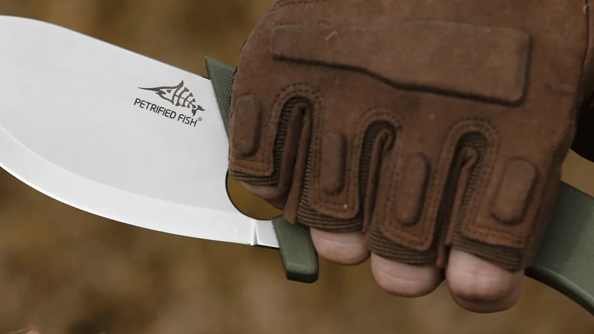 Closeup of gloved hand holding Petrified Fish PFH01 EEL knife