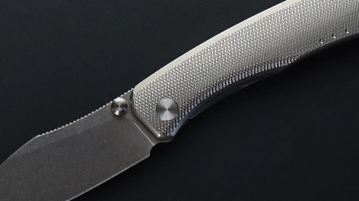 Closeup of Quiet Carry The Catch handle and blade on black background