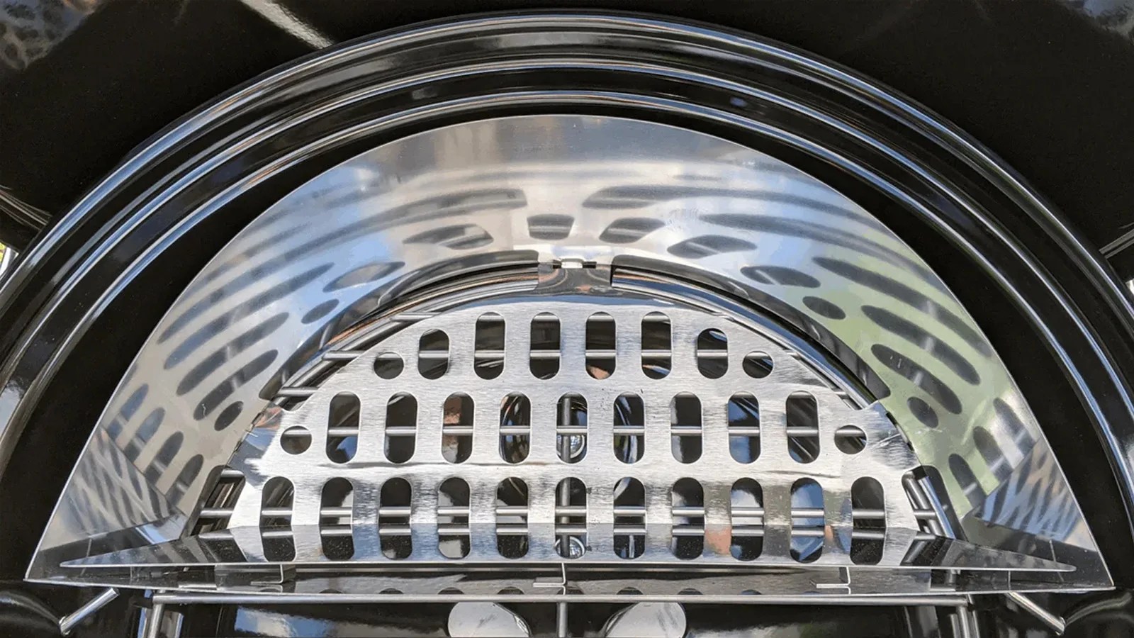A top down image of an SNS charcoal grill basket in a clean webber kettle grill