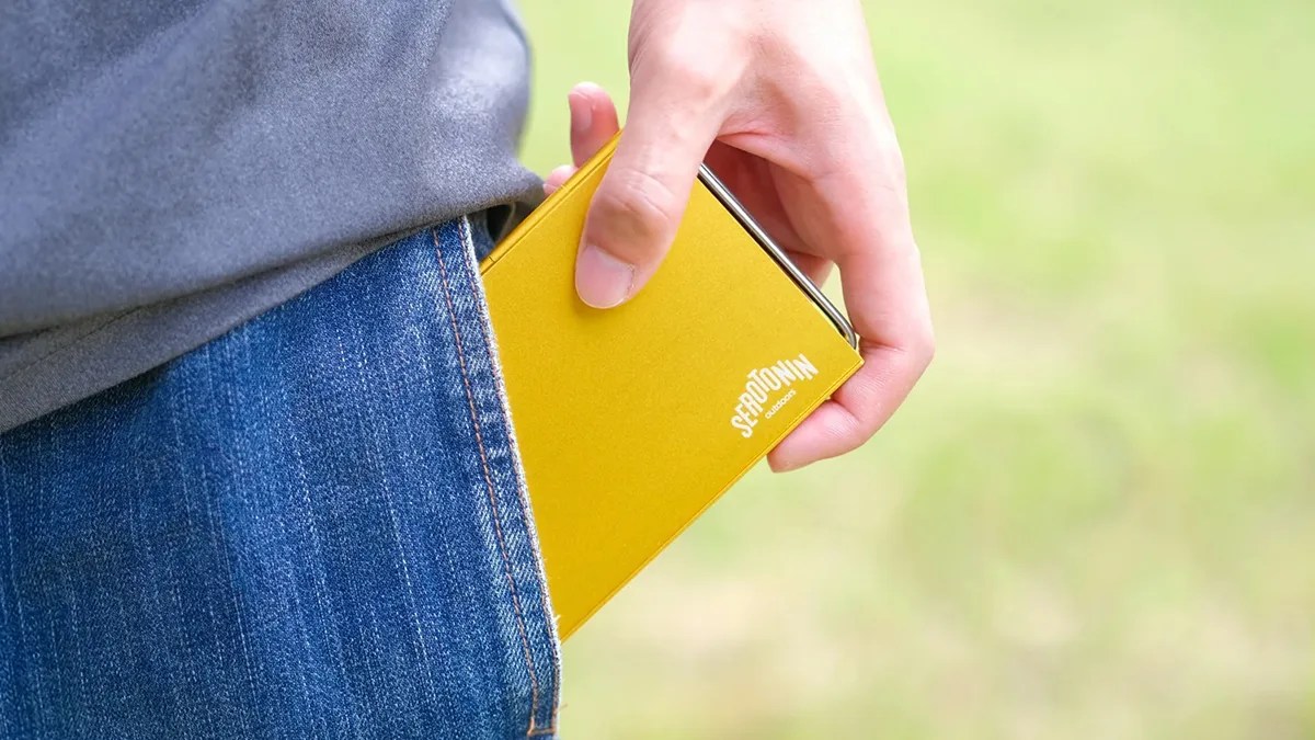 Serotonin Outdoors Pocket Mini Table being pulled from someone's jeans pocket by hand
