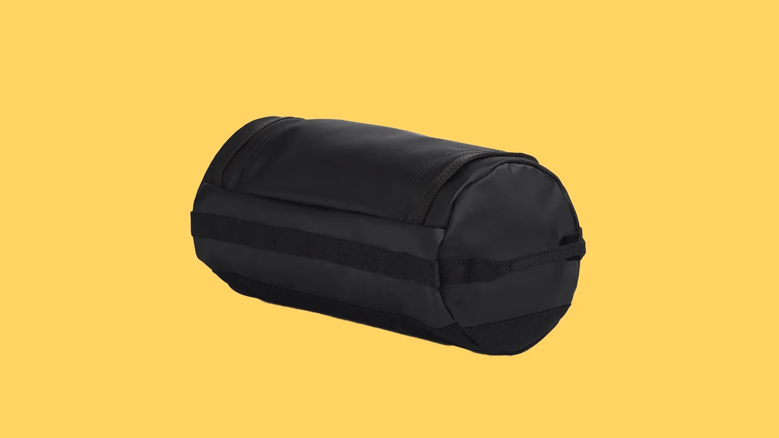 The North Face Base Camp Travel Canister bag in black shown at an angle from behind against a bright yellow background