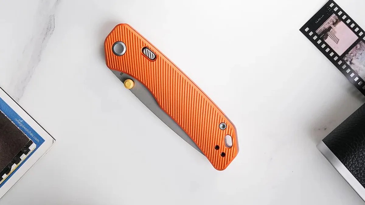 Vosteed Marten knife on desk between photo strip and magazine