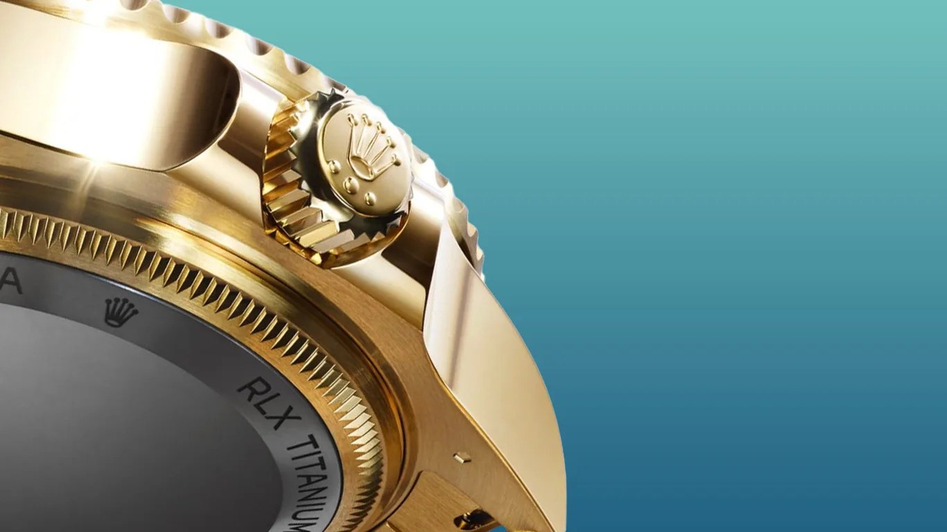 a closeup of the back and side of a gold rolex dive watch